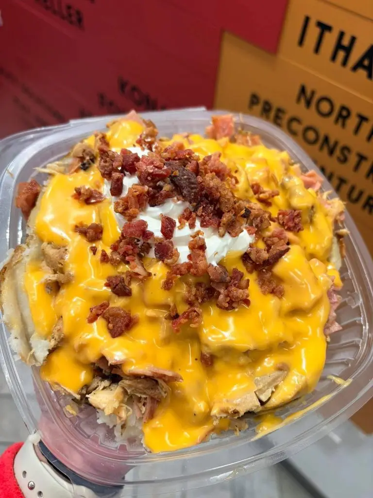 Loaded baked potato with cheese sauce, sour cream, and bacon