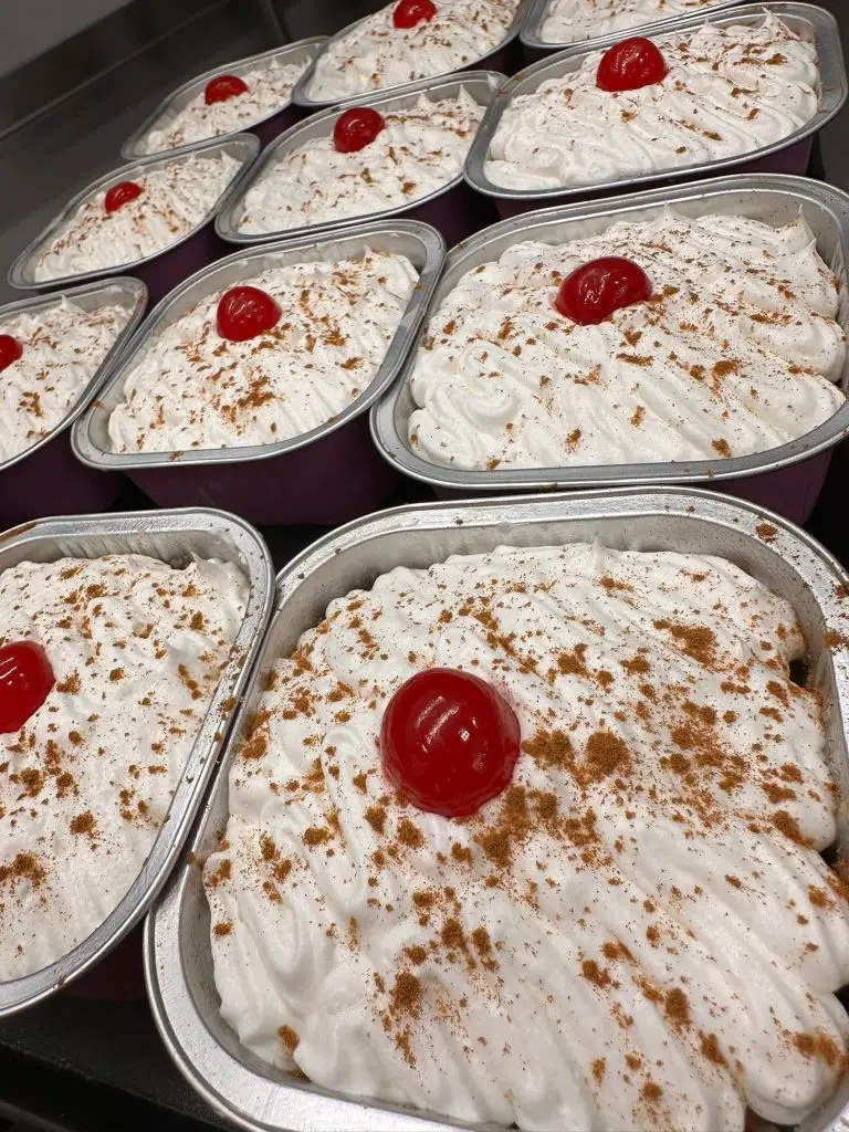 Individual tres leches cakes with whipped cream, cinnamon, and cherry